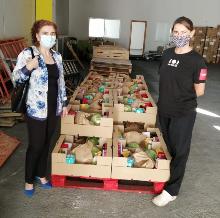 Dos personas recogen alimentos para las familias en situación de vulnerabilidad económica en un almacén
