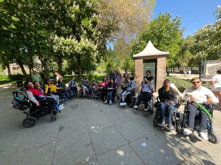 Usuarios y Usuarias de Aspace Madrid posan colocados en circulo en un parque