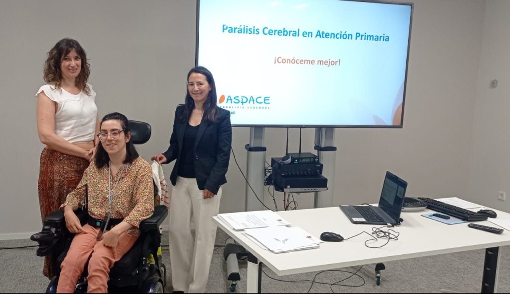 Tres personas posan durante una formación de Aspace Madrid en una sala de reuniones